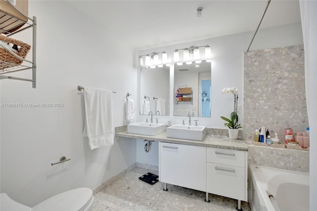 bathroom with a tub, vanity, and toilet