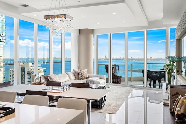 sunroom / solarium with an inviting chandelier and a water view