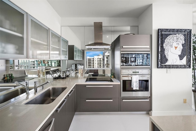 kitchen featuring stainless steel oven, wall chimney range hood, sink, and black electric stovetop