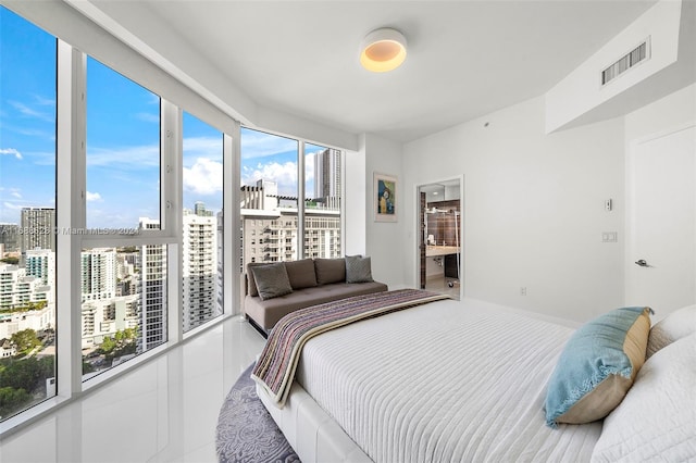 bedroom with ensuite bathroom and tile patterned flooring