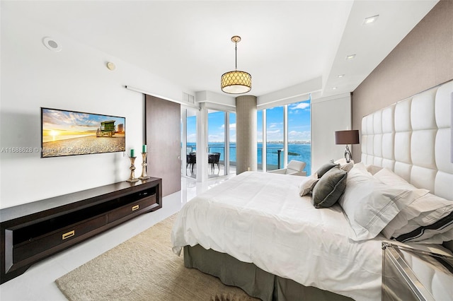 bedroom with a water view and access to exterior