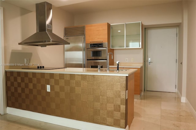 kitchen with range hood, appliances with stainless steel finishes, light tile patterned floors, sink, and kitchen peninsula