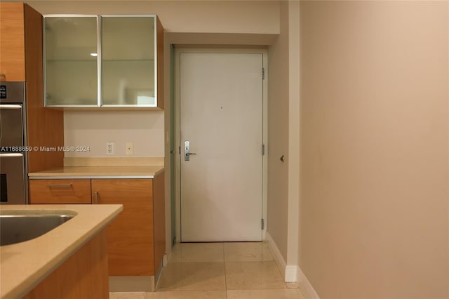 kitchen featuring stainless steel double oven and light tile patterned floors