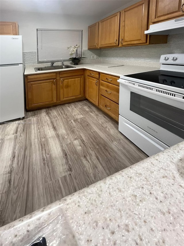 kitchen featuring white appliances, sink, and light hardwood / wood-style floors