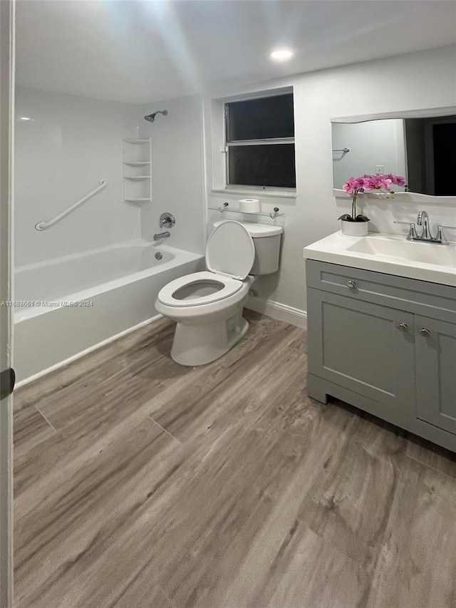 full bathroom with hardwood / wood-style floors, vanity, toilet, and bathtub / shower combination