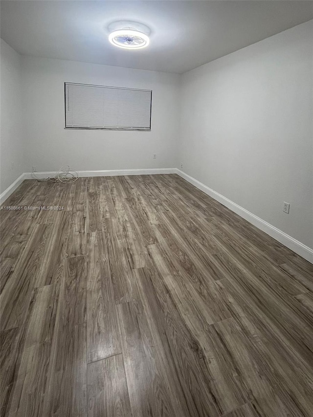 empty room with dark hardwood / wood-style flooring