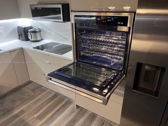 111 Golden Isles Dr Unit G5, Hallandale Beach, FL 33009 - kitchen with stainless steel appliances, wood finished floors, and light countertops