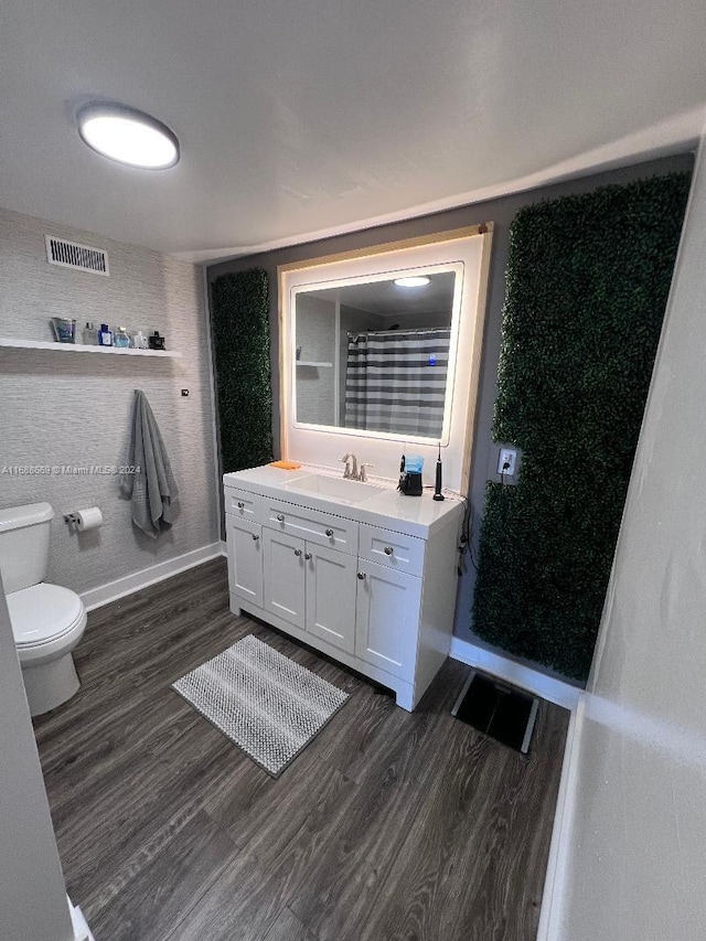 bathroom featuring hardwood / wood-style flooring, vanity, and toilet