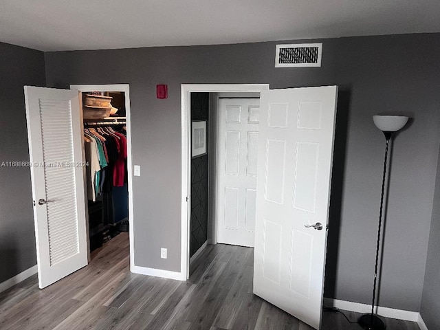 111 Golden Isles Dr Unit G5, Hallandale Beach, FL 33009 - unfurnished bedroom featuring wood finished floors and a walk in closet