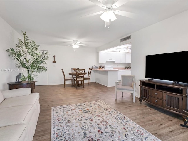 living room featuring ceiling fan and light hardwood / wood-style floors