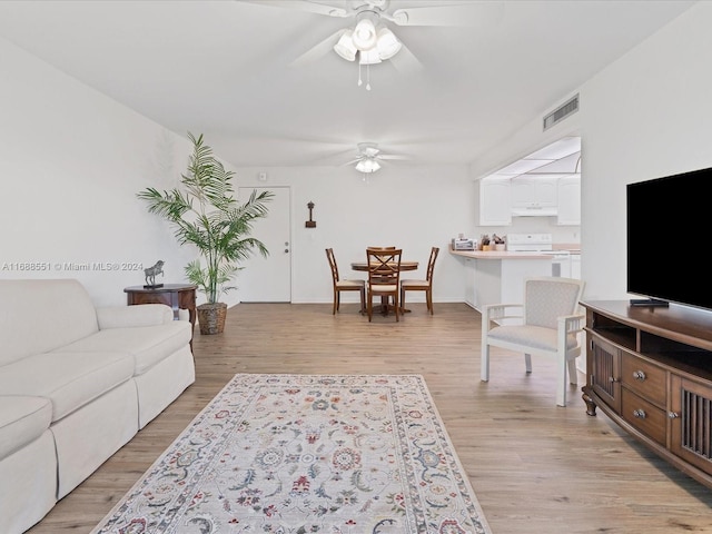 living room with light hardwood / wood-style floors and ceiling fan