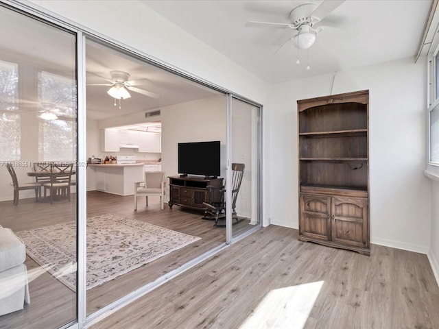 living room with ceiling fan and light hardwood / wood-style floors