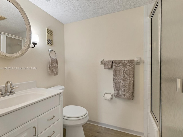 full bathroom with a textured ceiling, vanity, hardwood / wood-style flooring, and toilet