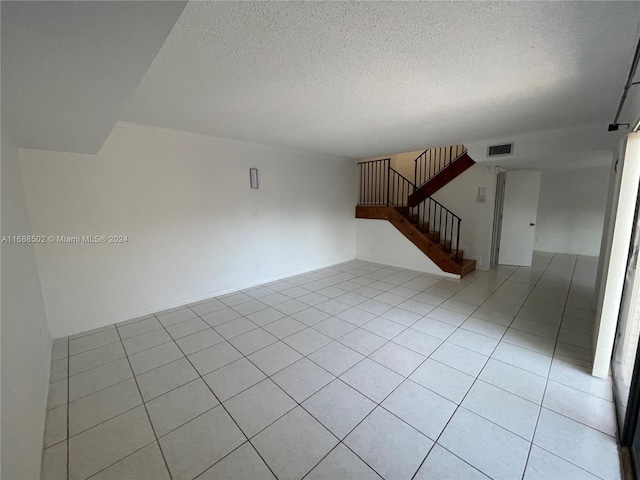 tiled spare room featuring a textured ceiling