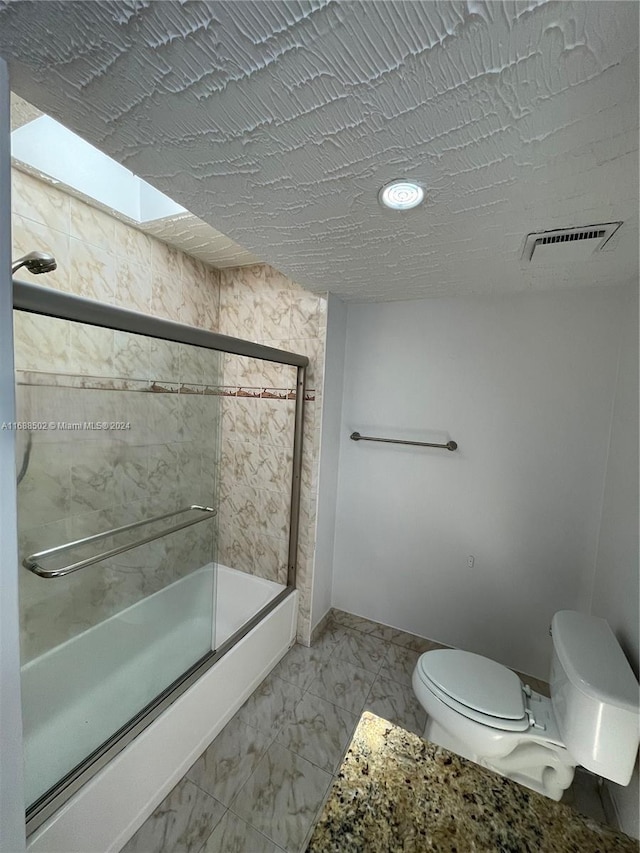 bathroom with a shower with shower door and toilet