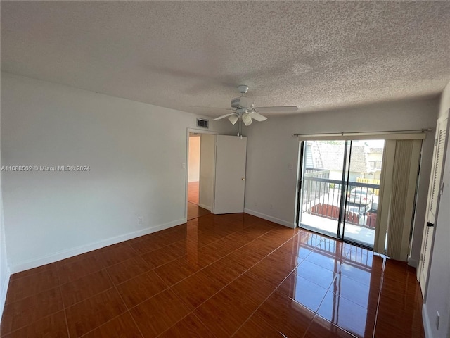 tiled empty room featuring a textured ceiling and ceiling fan