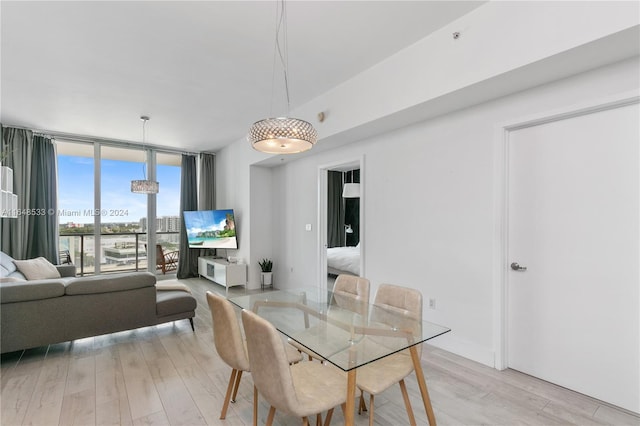 dining space featuring a wall of windows and light hardwood / wood-style floors