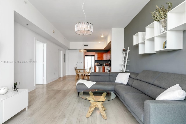 living room featuring light wood-type flooring and a notable chandelier