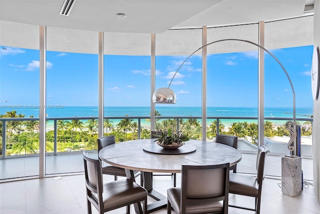 sunroom featuring a beach view and a water view