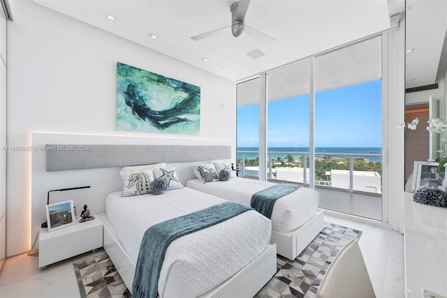 bedroom featuring access to outside, a water view, floor to ceiling windows, and ceiling fan