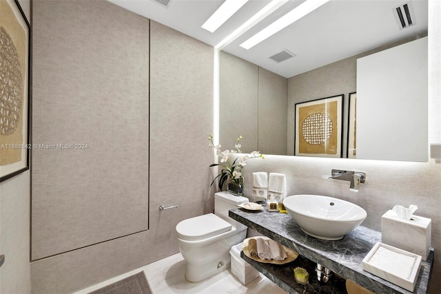 bathroom featuring toilet, vanity, and tile patterned flooring