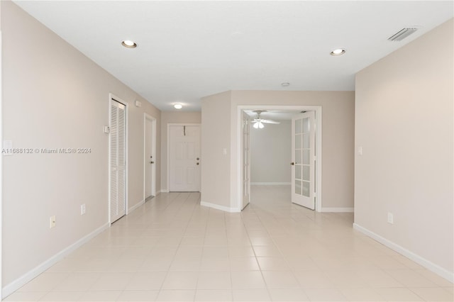 empty room with light tile patterned floors and french doors