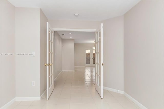 corridor with french doors and light tile patterned floors