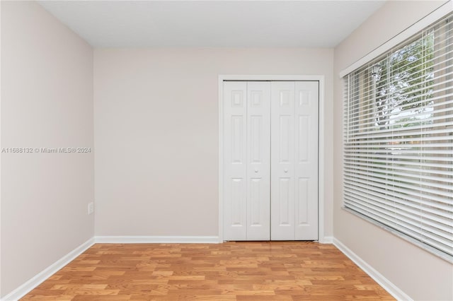 unfurnished bedroom featuring light hardwood / wood-style flooring and a closet