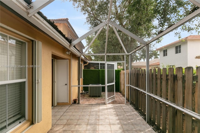 view of patio featuring central air condition unit and a lanai