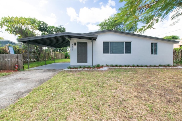 ranch-style house featuring a carport and a front lawn