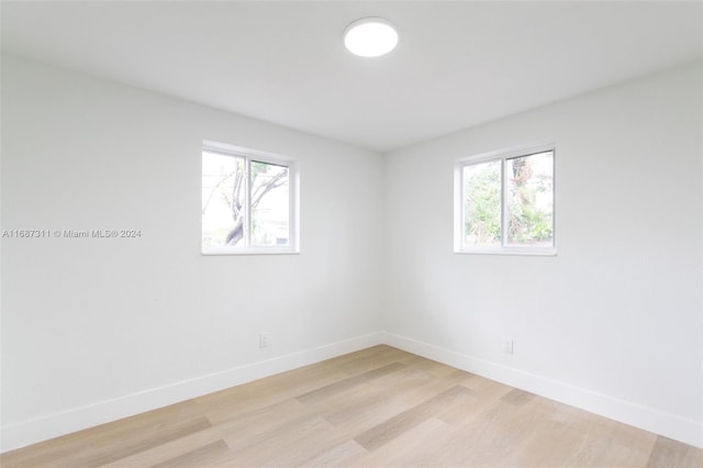 spare room with a wealth of natural light and light hardwood / wood-style flooring