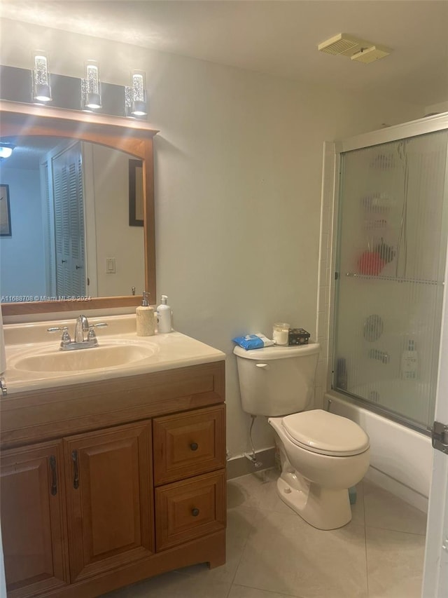 full bathroom with toilet, vanity, tile patterned flooring, and enclosed tub / shower combo