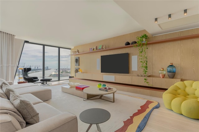 living room featuring hardwood / wood-style flooring, a wall of windows, and wooden walls