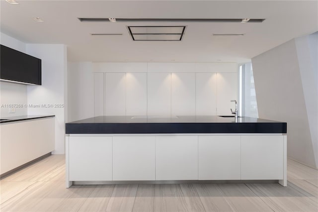 1000 Biscayne Blvd Unit 2702, Miami, FL 33132 - kitchen with dark countertops, white cabinetry, modern cabinets, and a center island with sink