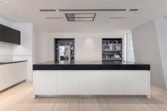 kitchen with sink, white cabinets, and a spacious island