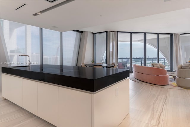 1000 Biscayne Blvd Unit 2702, Miami, FL 33132 - kitchen with dark countertops, white cabinetry, open floor plan, a wall of windows, and modern cabinets