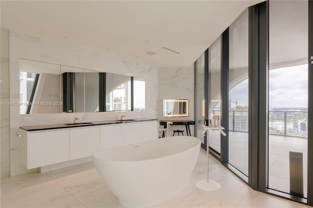 bathroom featuring vanity, a bathtub, and a wall of windows