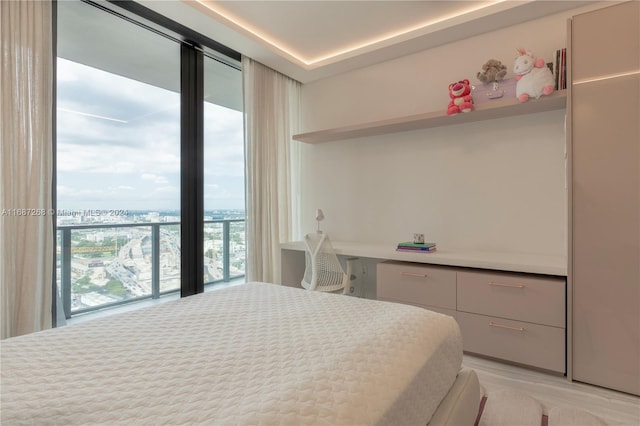 bedroom with built in desk and light wood-type flooring