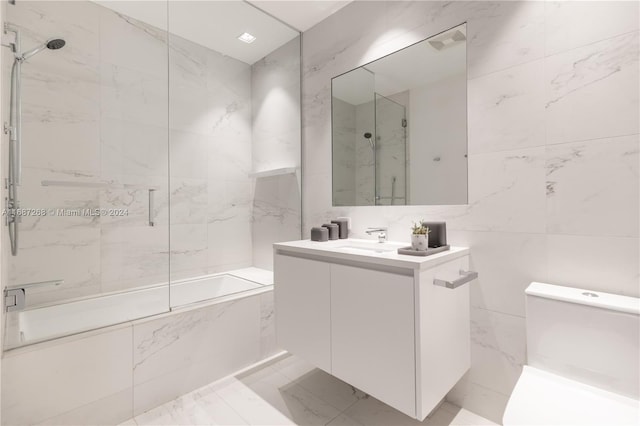 bathroom with tile walls, vanity, and enclosed tub / shower combo