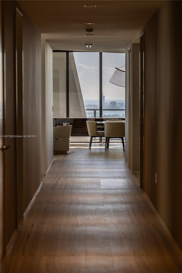 hallway featuring a water view, hardwood / wood-style floors, and a wall of windows