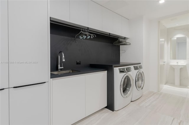 washroom featuring cabinets, washer and clothes dryer, and sink