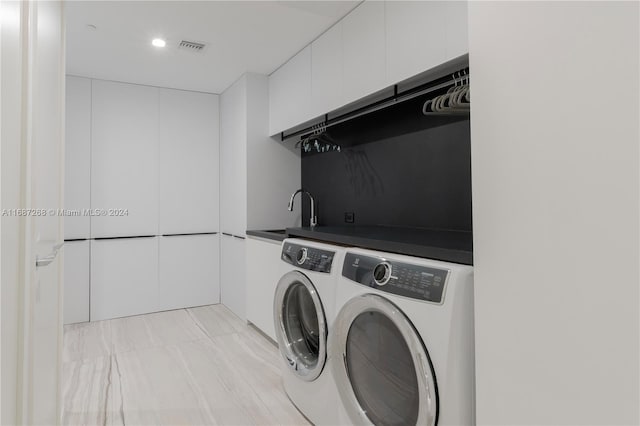 clothes washing area featuring cabinets, sink, and washing machine and dryer