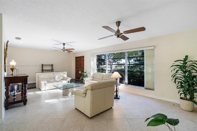 tiled living room with ceiling fan and a textured ceiling