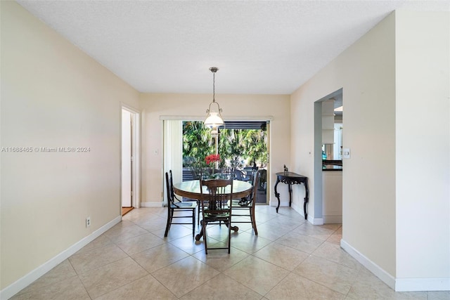 dining room with a textured ceiling and light tile patterned floors