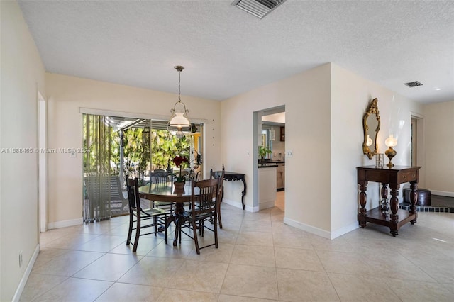 dining room featuring a textured ceiling and light tile patterned floors