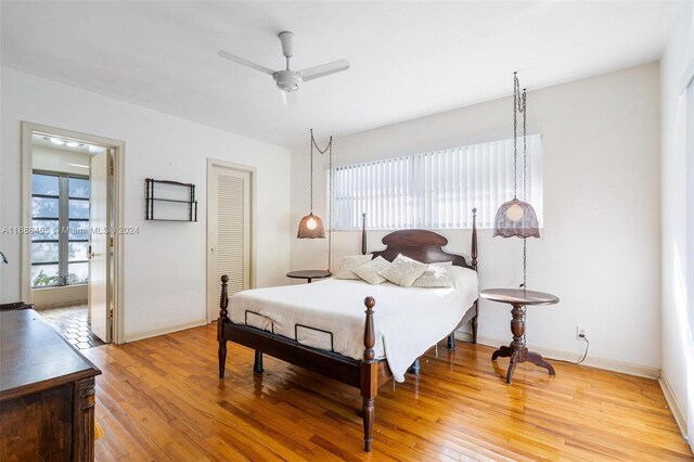 bedroom with light hardwood / wood-style floors, ceiling fan, and a closet