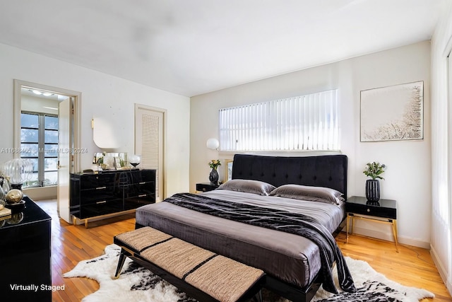 bedroom featuring a closet, multiple windows, and light hardwood / wood-style flooring