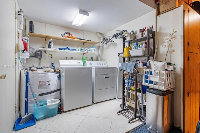 laundry room featuring washing machine and dryer and light tile patterned flooring