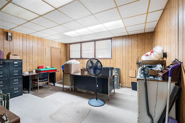 miscellaneous room featuring a drop ceiling and wooden walls