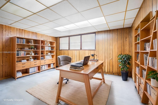 office area featuring built in shelves, a paneled ceiling, and wooden walls